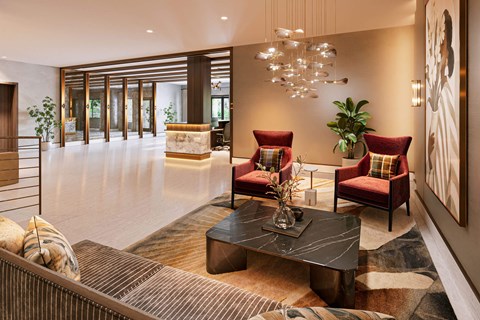 A modern living room with a black coffee table and red chairs.