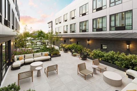 A patio with a white couch, chairs, and tables.
