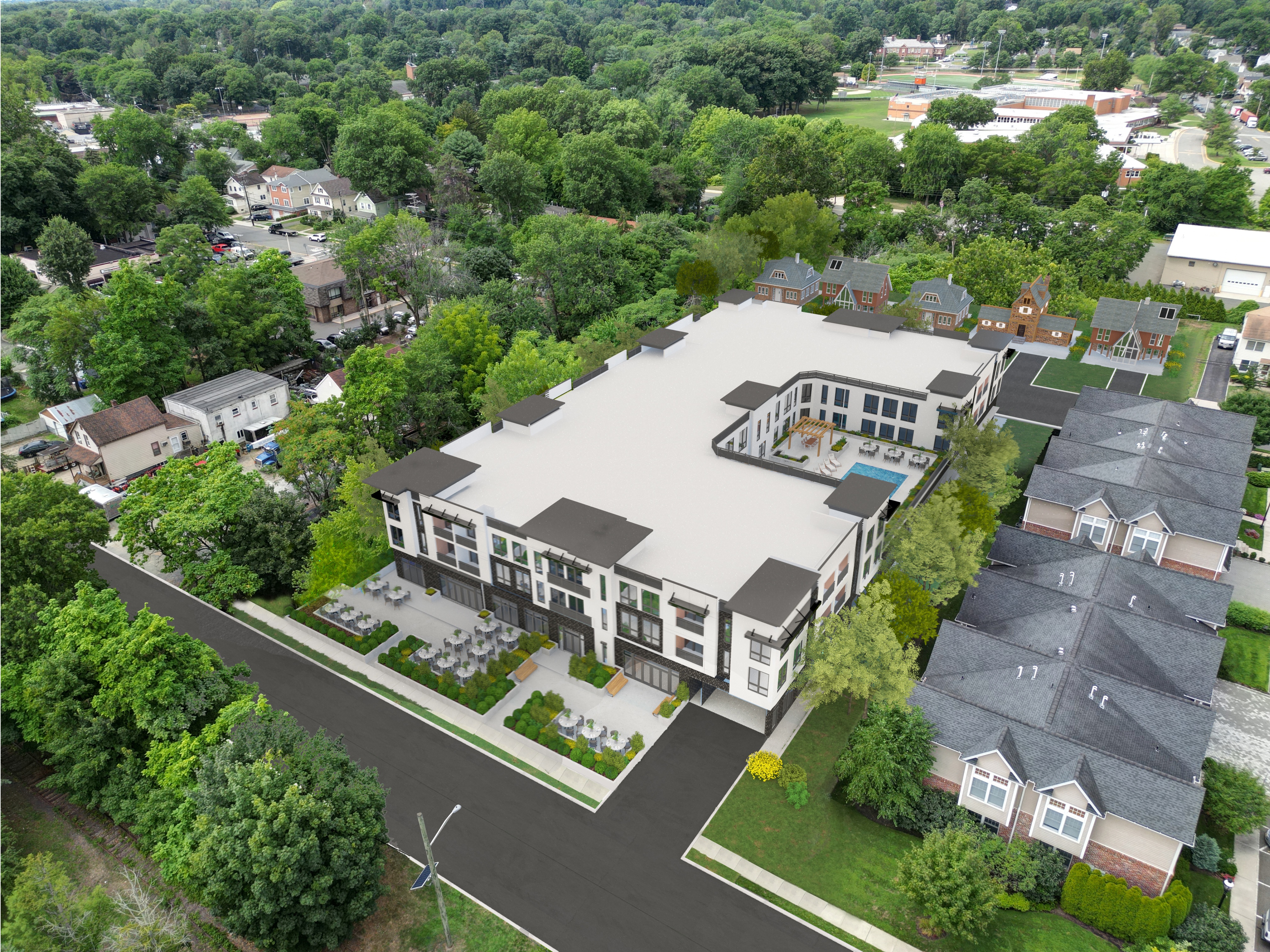 An aerial view of a modern building surrounded by trees and other buildings.