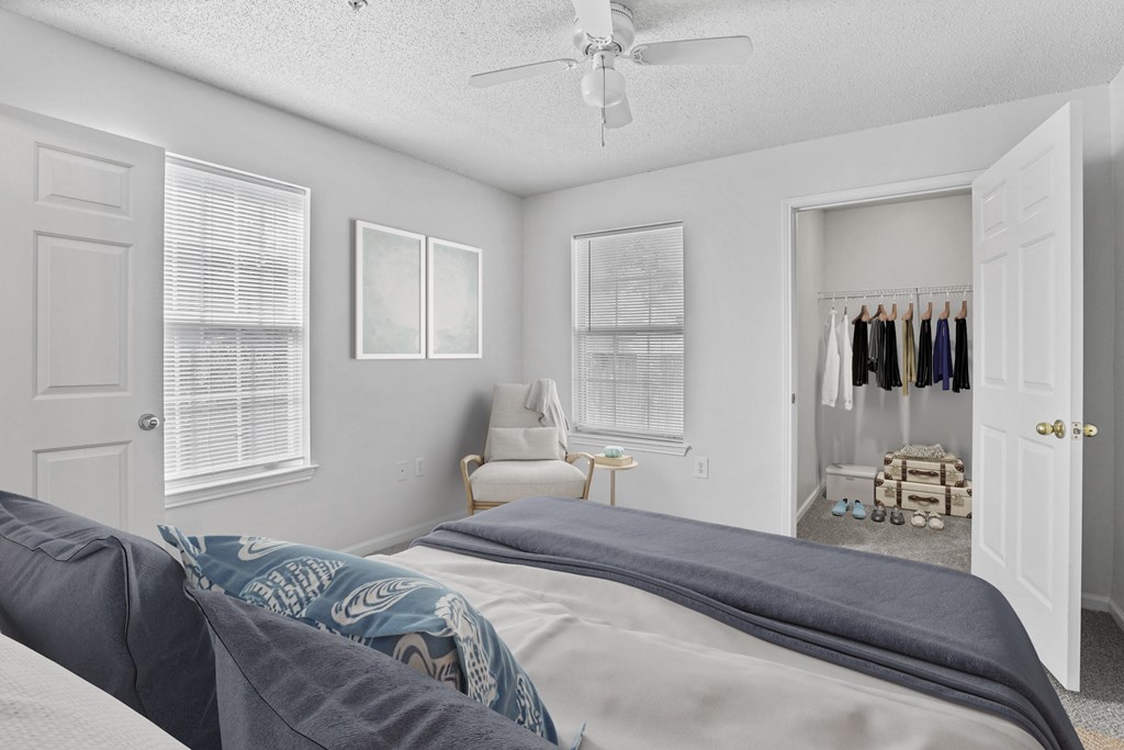 A bedroom with a bed, a chair, and a closet.