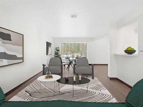 A living room with a black and white rug and two grey chairs.