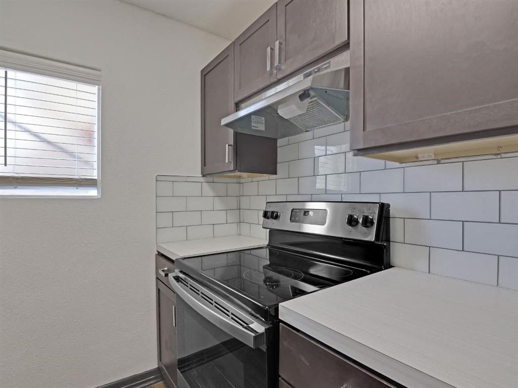 a kitchen with a stove and a window