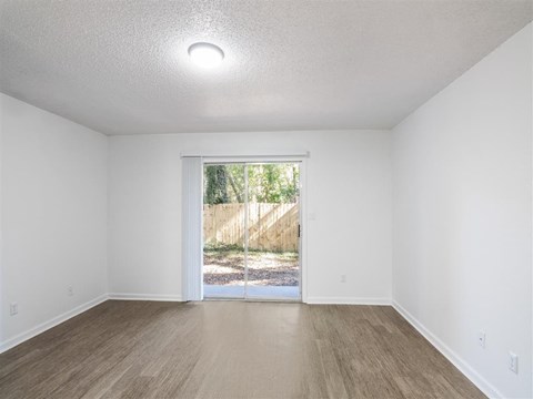 A room with a sliding glass door leading to a backyard.