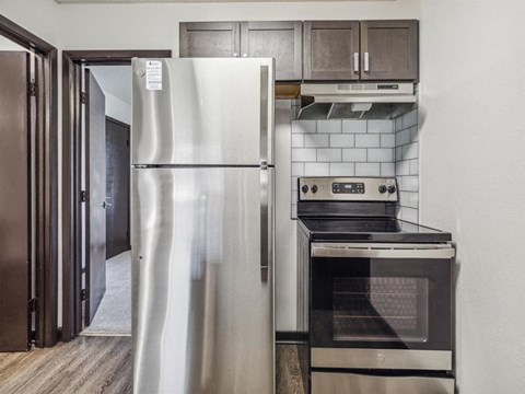 A modern kitchen with a stainless steel refrigerator and oven.