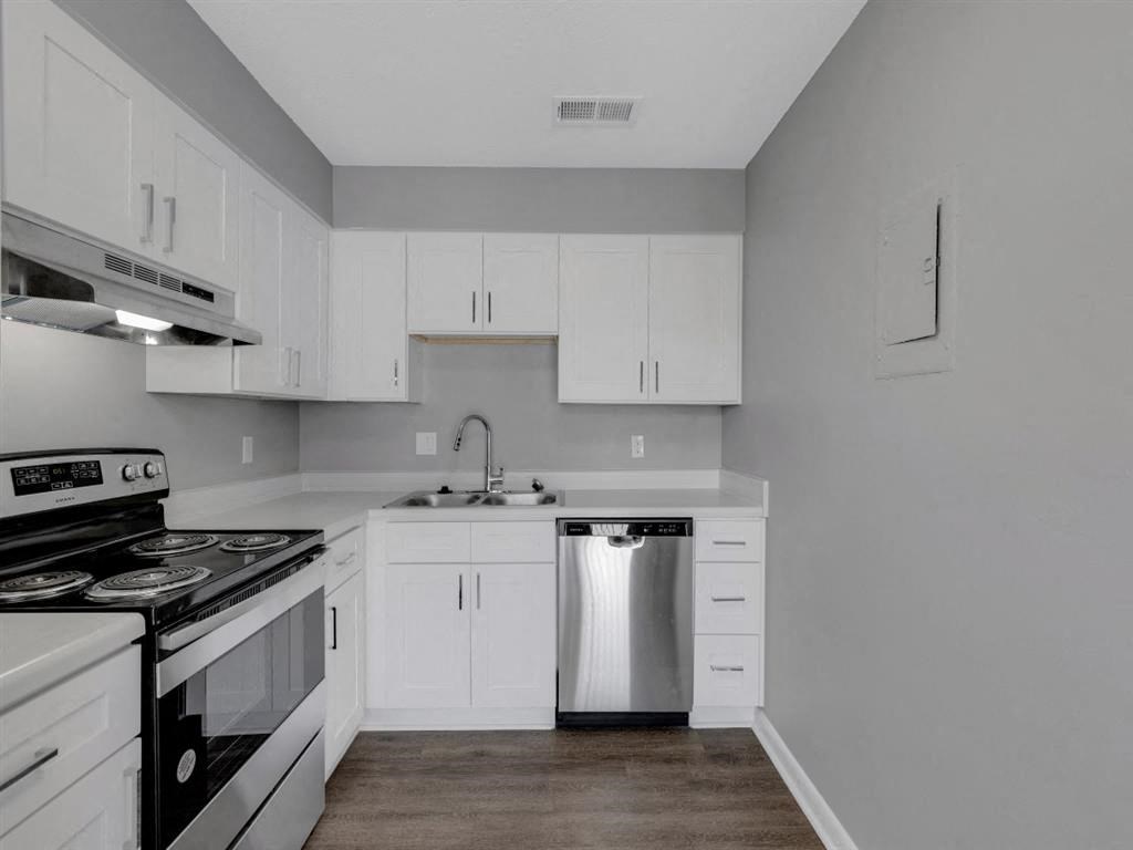 a white kitchen with stainless steel appliances and white cabinets
