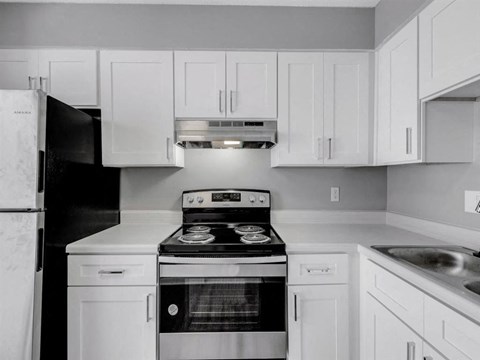 a white kitchen with a stove and a refrigerator
