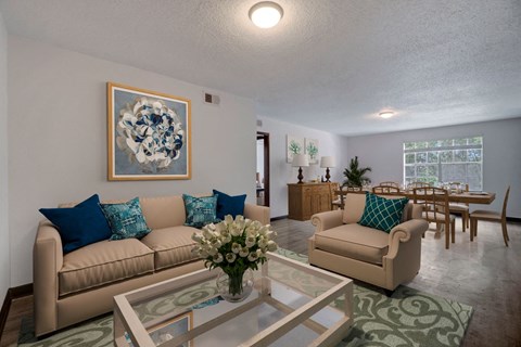 a living room and dining room with couches and a table