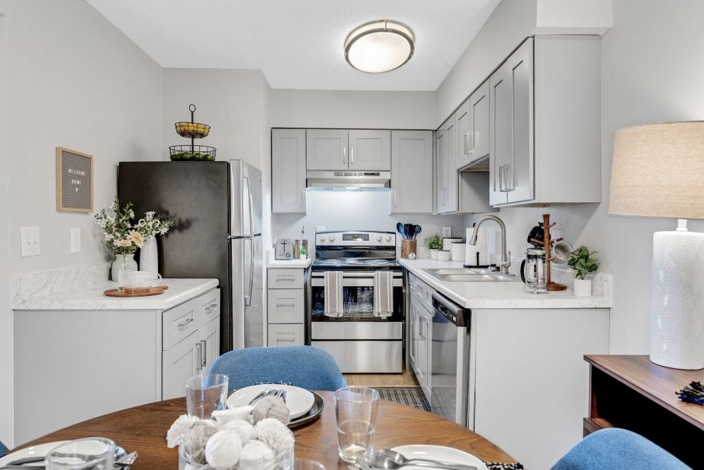 A modern kitchen with a dining table set for two. A modern kitchen with a dining table set for two. at The Beacon, Huntsville, AL, 35816