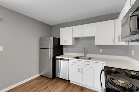 a kitchen with white cabinets and a stainless steel refrigerator