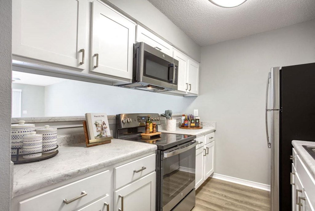 a kitchen with stainless steel appliances and white cabinets