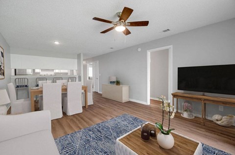 a living room and dining room with a ceiling fan
