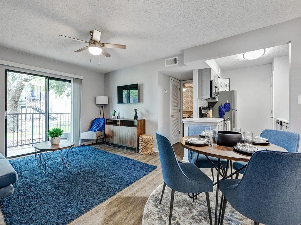 a living room and dining room with a sliding glass door at The Emory, Pensacola, FL