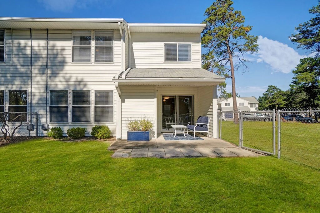 a white house with a patio and a grassy yard a white house with a patio and a grassy yard at Estates at Palm Bay, Fort Walton Beach, Florida