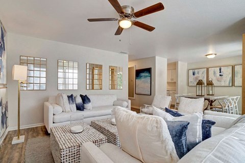 A living room with a white couch and a ceiling fan.