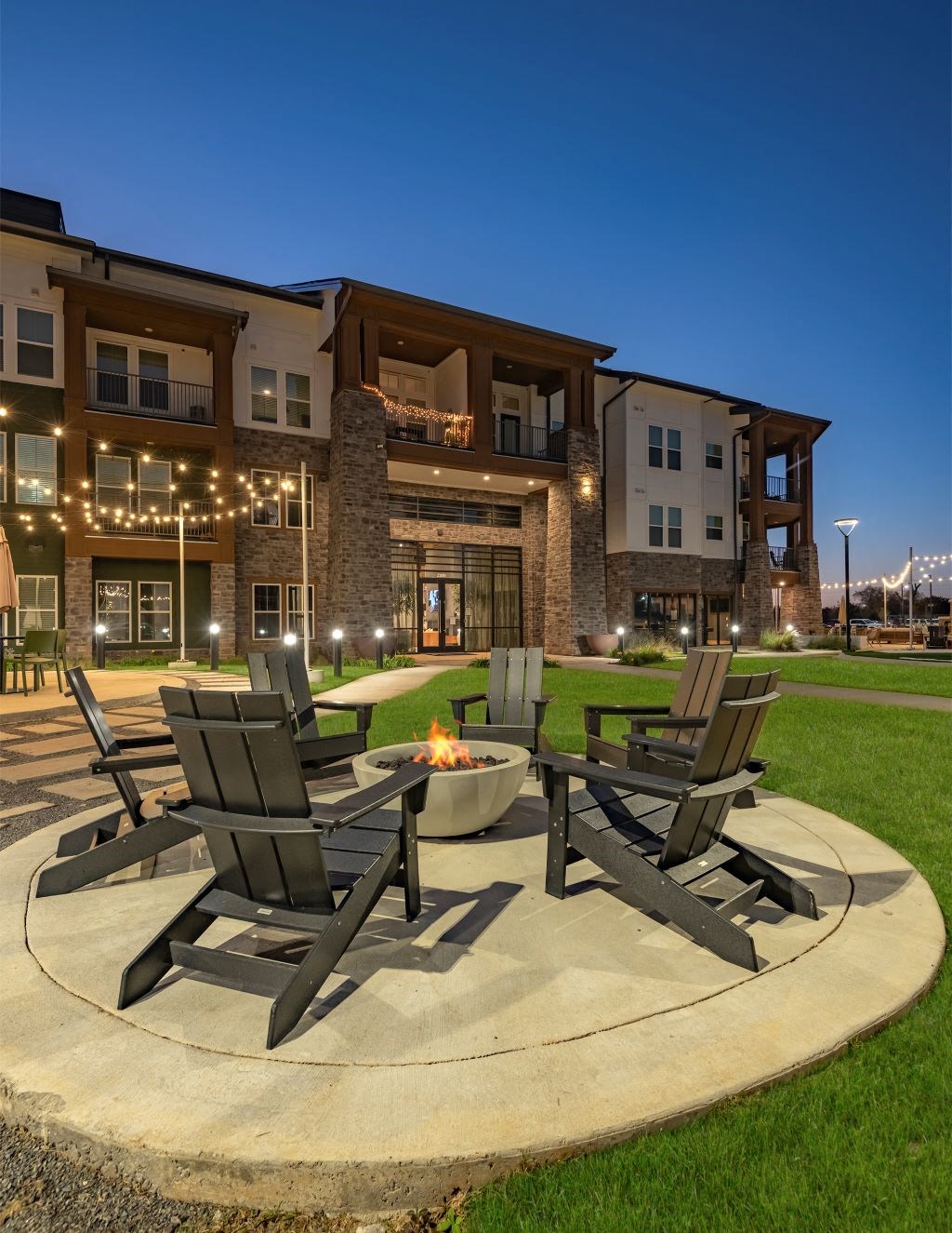 a patio with chairs and a fire pit in front of a building at Fitzroy Grove, Arkansas