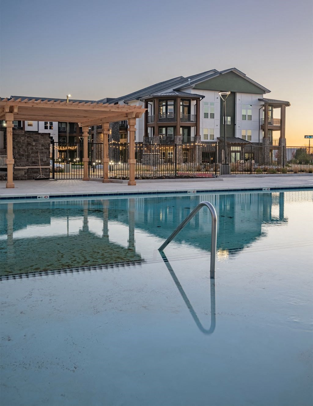 a swimming pool with a building in the background at Fitzroy Grove, Rogers, AR