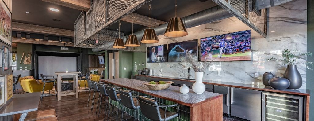 a restaurant with a long bar and a counter with chairs at Fitzroy Grove, Rogers, Arkansas