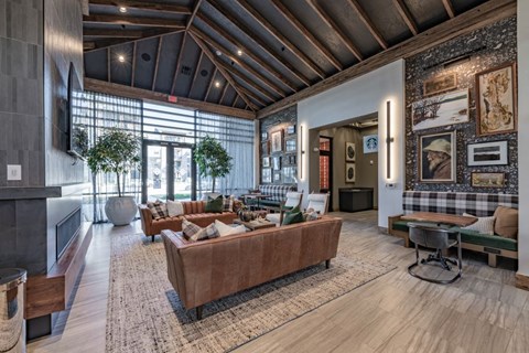A modern living room with a brown sofa and a wooden floor.