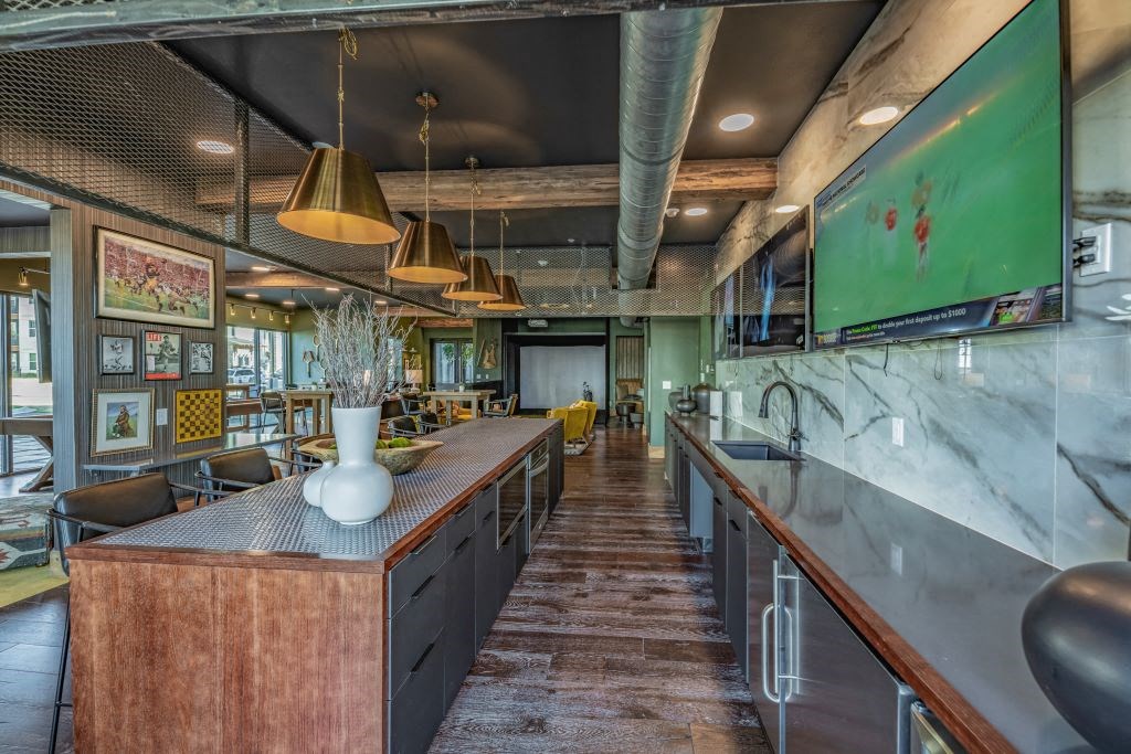 a restaurant with a long bar and a green painting on the wall at Fitzroy Grove, Rogers, Arkansas