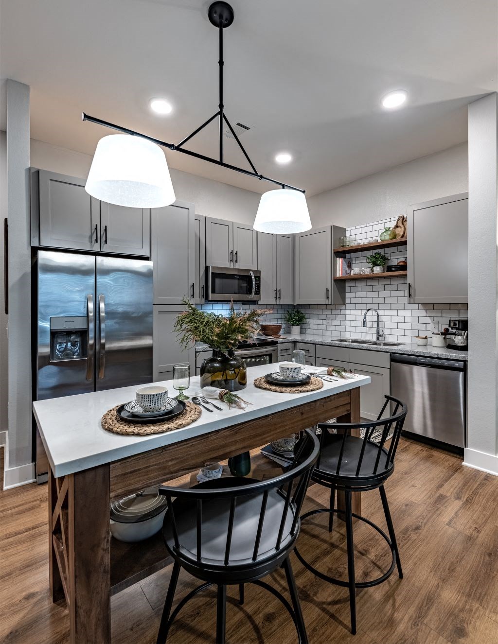 a kitchen with a large island with three chairs at Fitzroy Grove, Rogers, 72758