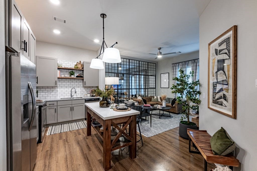 an open kitchen and living room area with a dining table at Fitzroy Grove, Rogers, AR