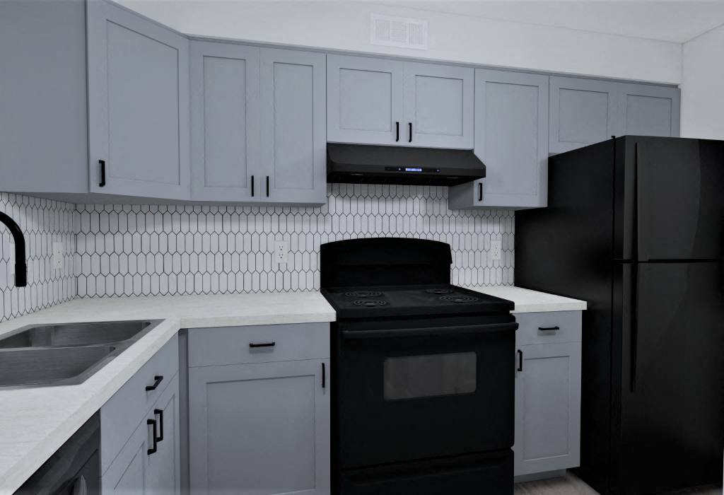 A black refrigerator sits next to a black oven in a kitchen.