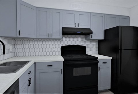 a kitchen with white cabinets and a black stove and refrigerator