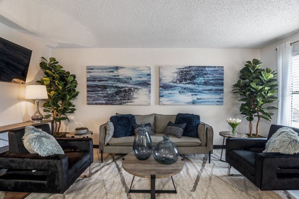 a living room with couches and a table at The Lorient Apartments, Pensacola, FL