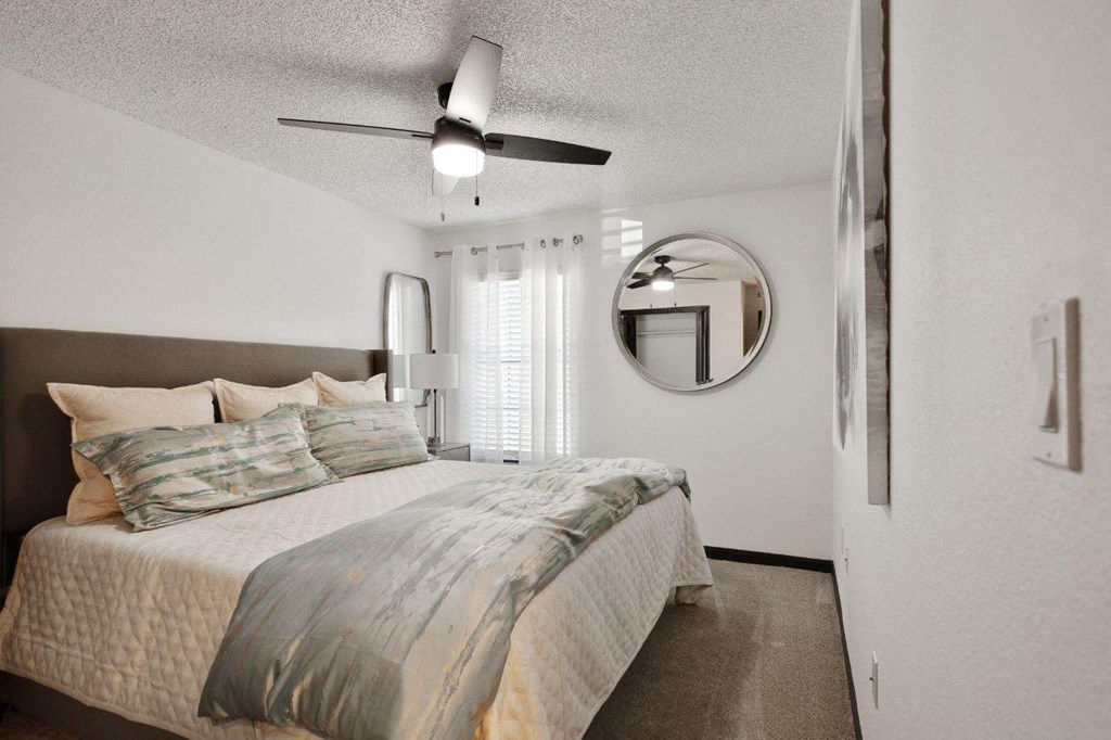 a bedroom with a bed and a ceiling fan at The Lorient Apartments, Pensacola, Florida