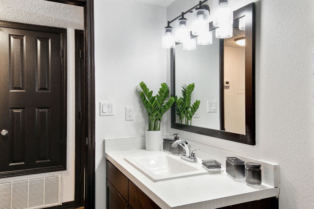 a bathroom with a sink and a mirror at The Lorient Apartments, Pensacola, Florida
