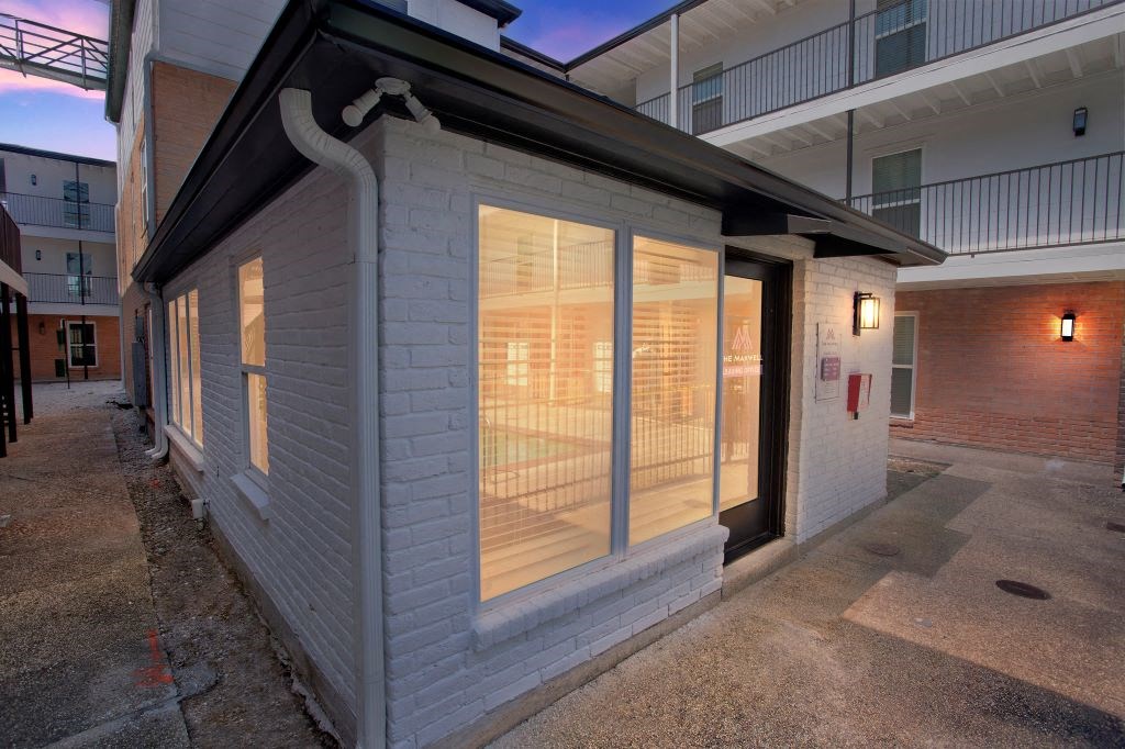 the front of a white building with glass windows