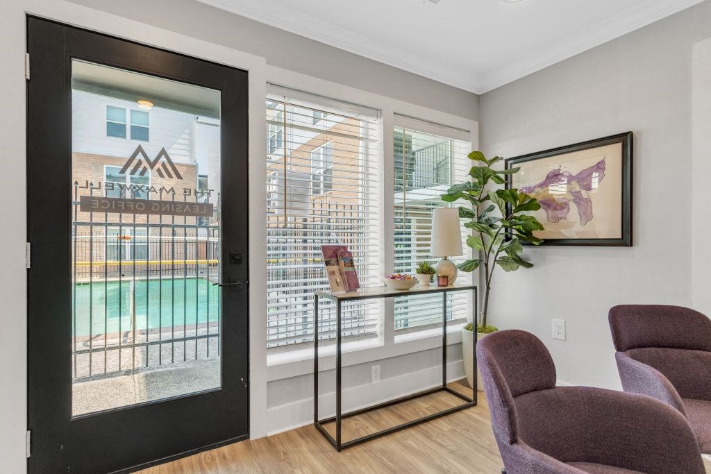 a living room with two chairs and a door to a balcony