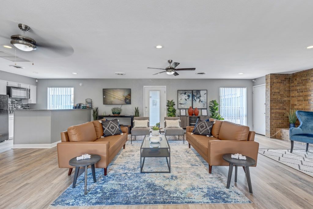 A living room with a blue rug and brown couches.