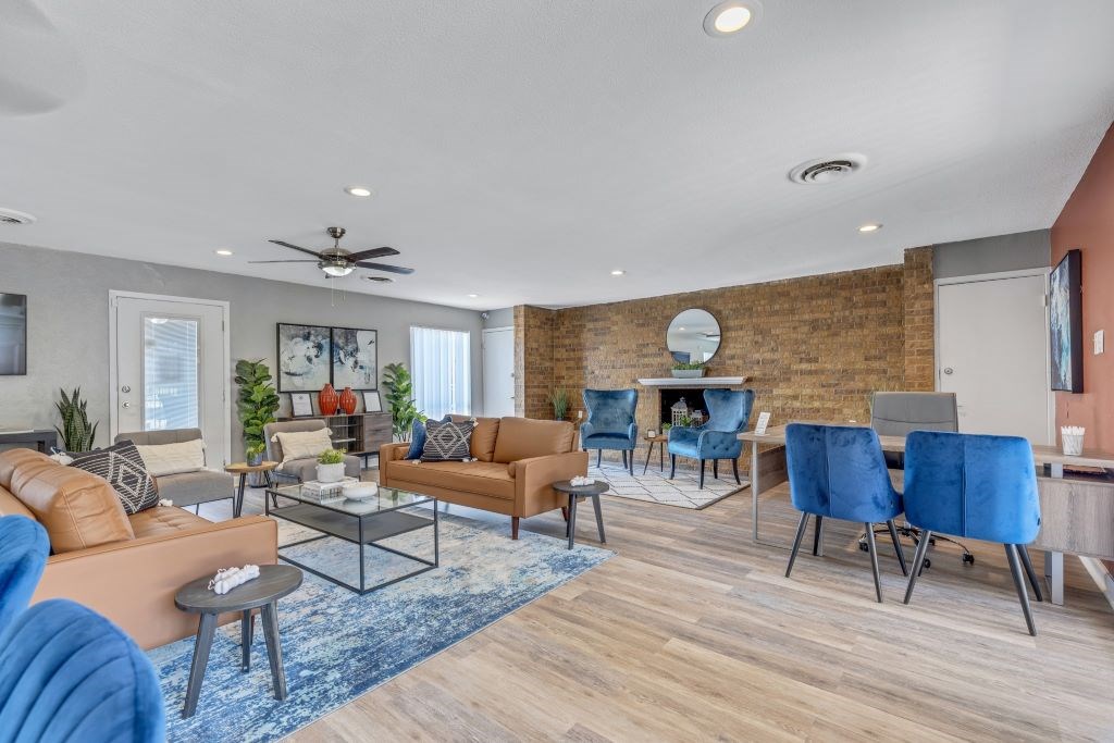 A living room with a brick wall and a variety of seating options.