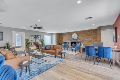 A living room with a brick wall and a variety of seating options.