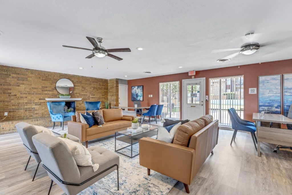 A living room with a brick wall and a ceiling fan.