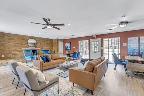 A living room with a brick wall and a ceiling fan.