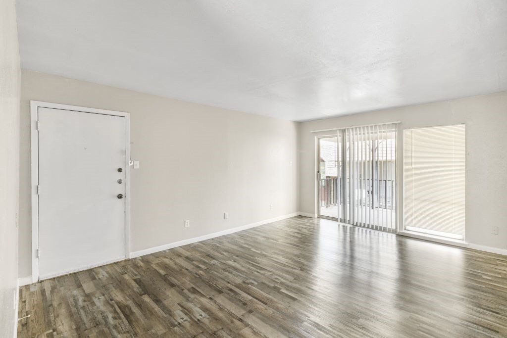 A room with wooden flooring and a white door.