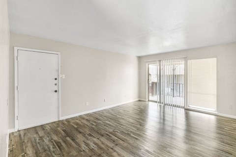 A room with wooden flooring and a white door.