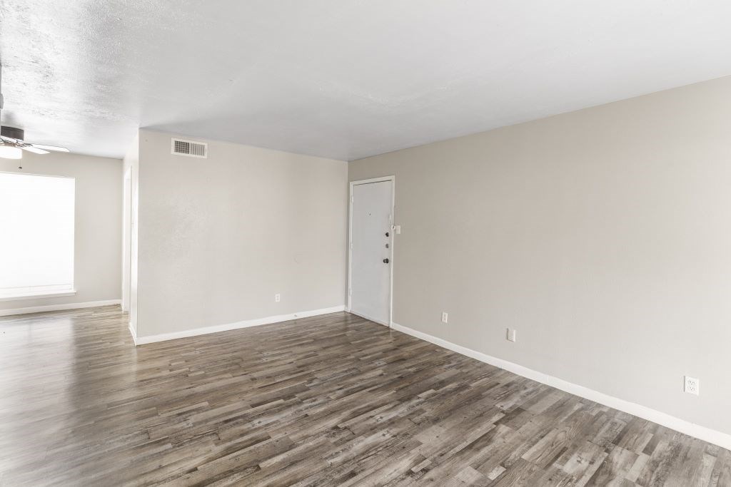 A room with wooden flooring and a white door.