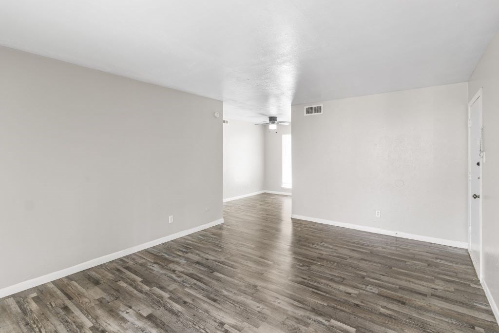 A room with wooden flooring and white walls.