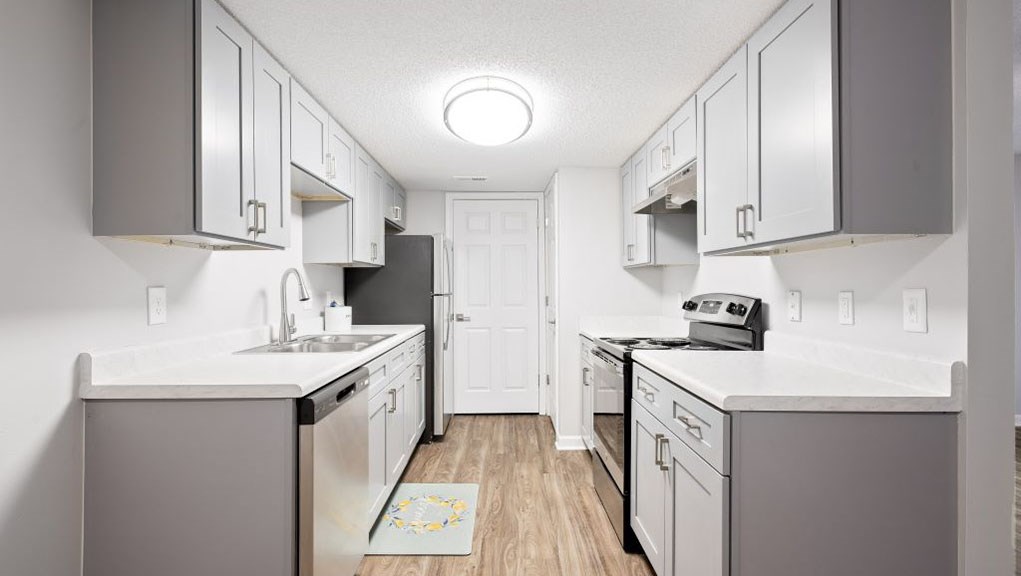 A kitchen with white cabinets and a white counter top.