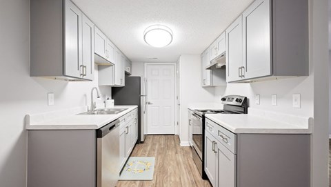 A kitchen with white cabinets and a white counter top.