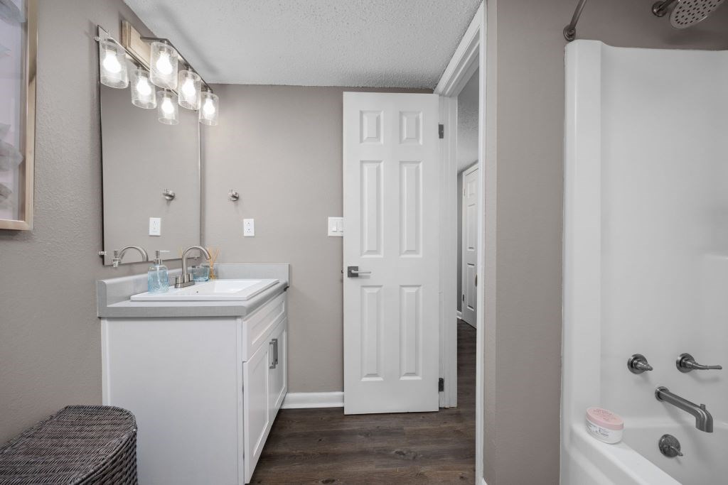 A white bathroom with a white sink and a white door.