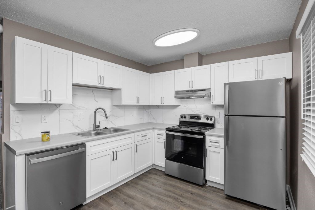 A kitchen with white cabinets and stainless steel appliances.