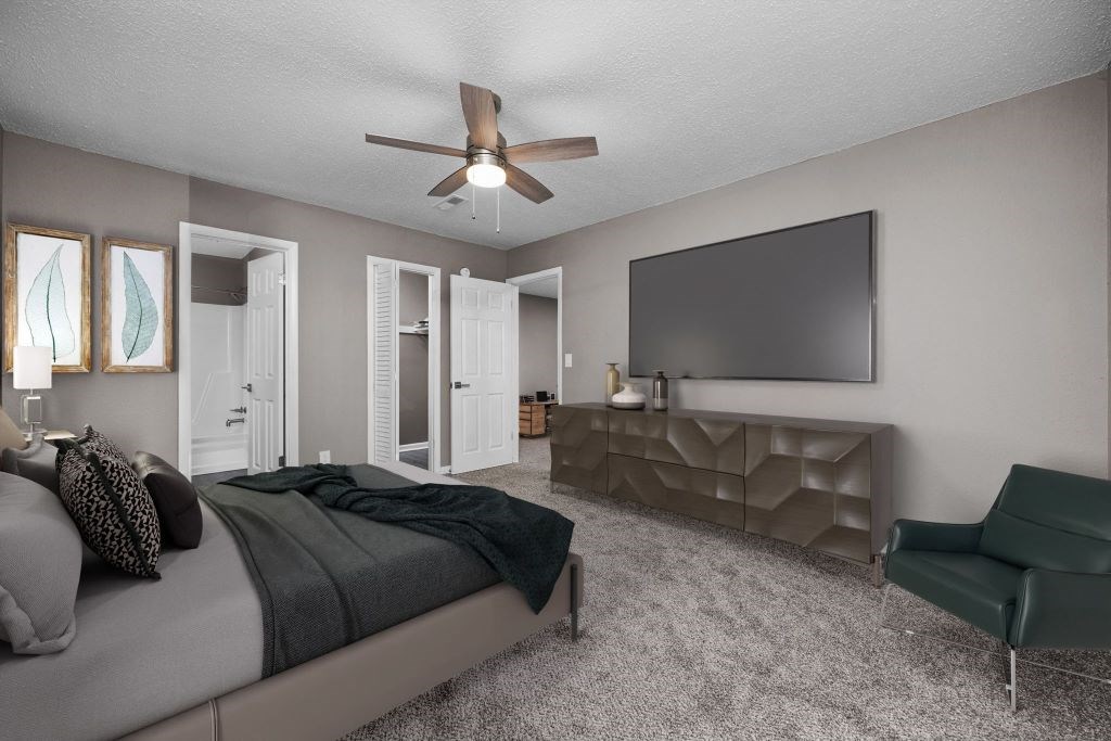 A bedroom with a bed, a chair, and a television.