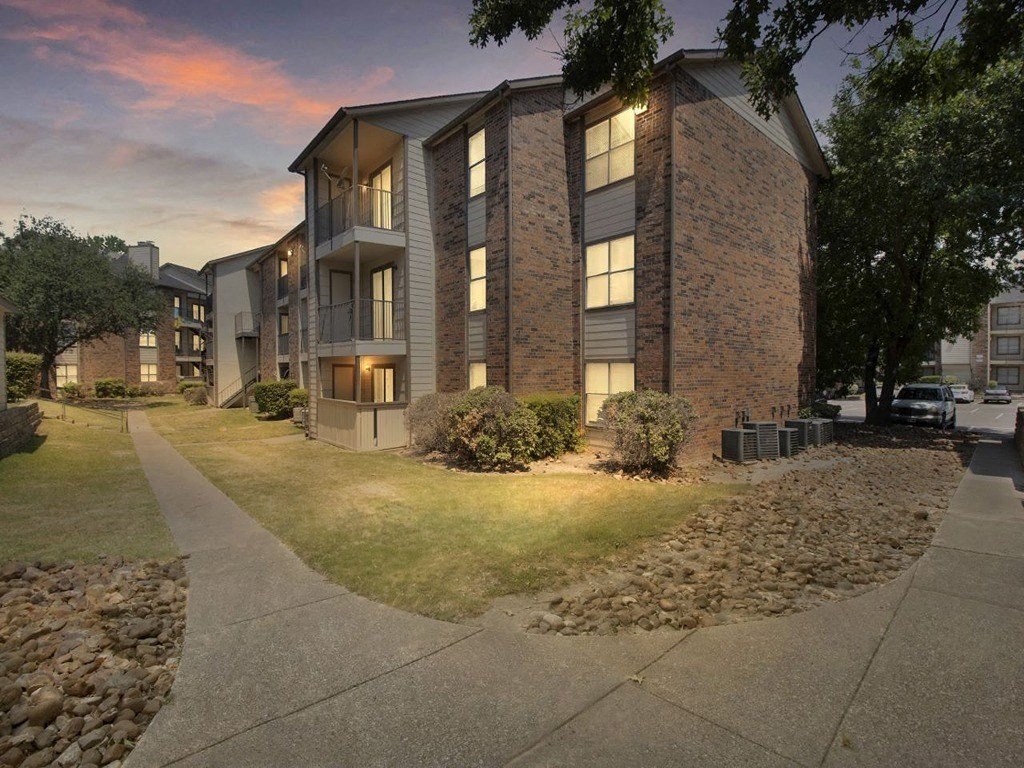 an apartment building with the lights on at dusk
