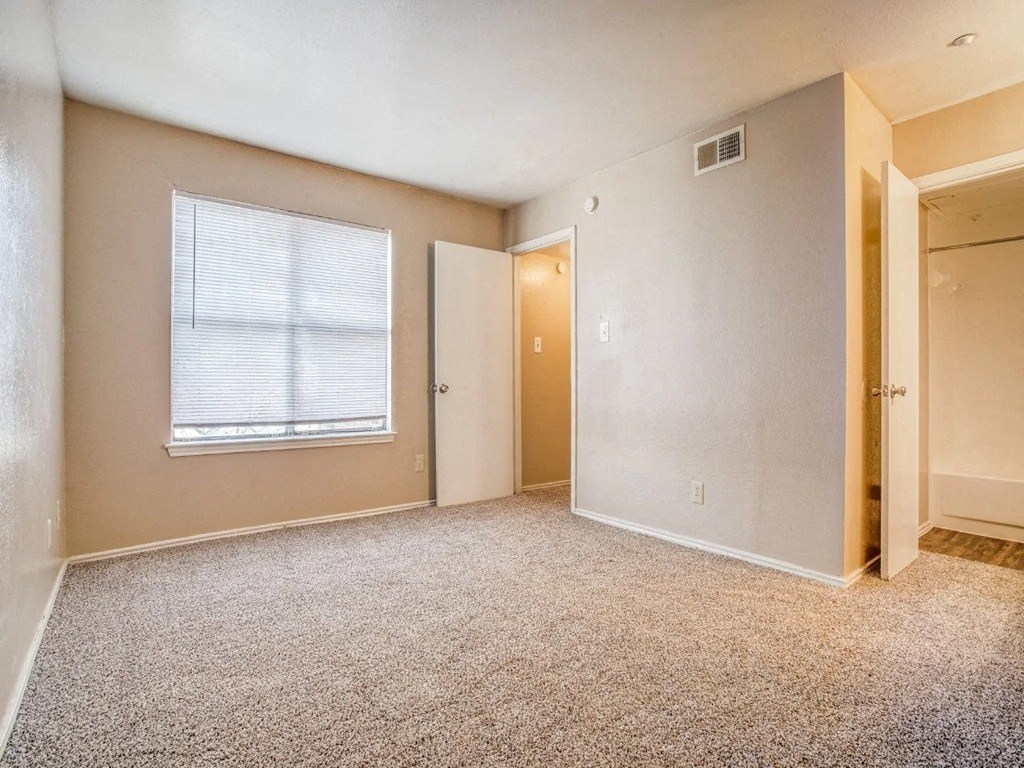 an empty room with a window and a door