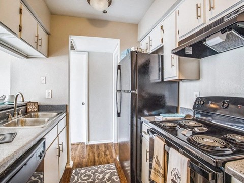 A kitchen with a black refrigerator and a black stove.