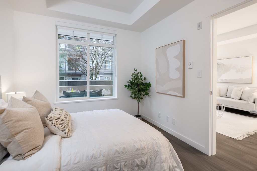 A bedroom with a large bed and a painting on the wall.